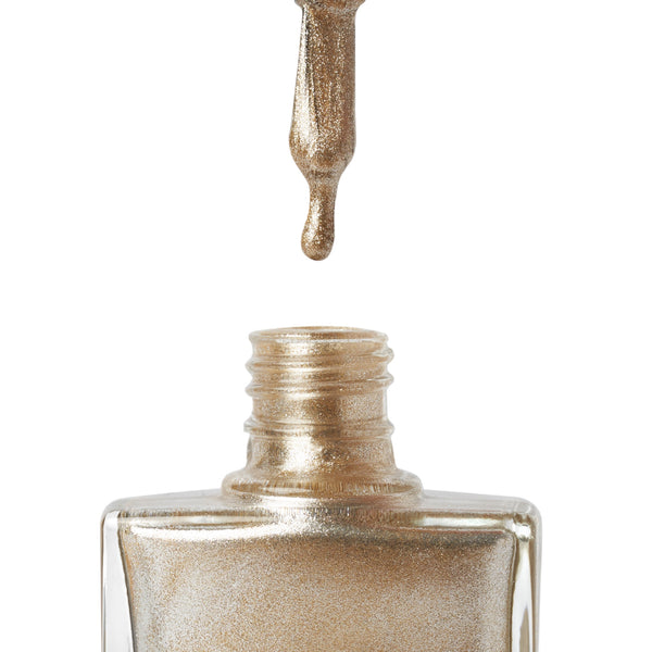 TRUE gold vegan nail polish close-up – metallic drop falling into open cruelty-free polish bottle