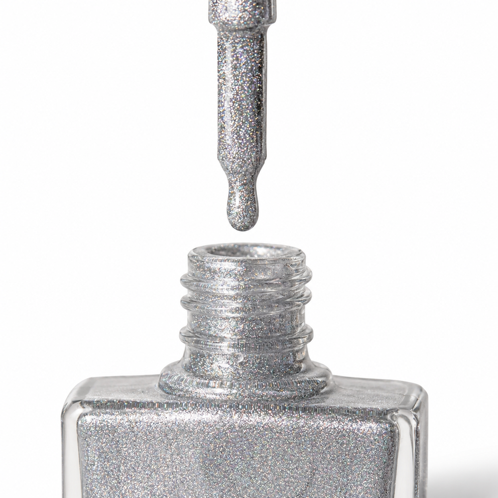 Bottle of Phenomenon silver holographic glitter vegan nail polish by TRUE Nail Polish with dazzling rainbow sparkle, glossy gel-effect finish and long-lasting chip-resistant formula.